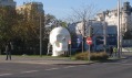 Rušná vídeňská křižovatka s monumentální bílou lebkou na okraji