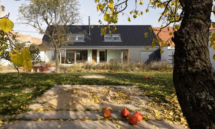 Rodinný dům Polánka navazuje jako tmavá hmota na blok domů a otevírá se do zahrady