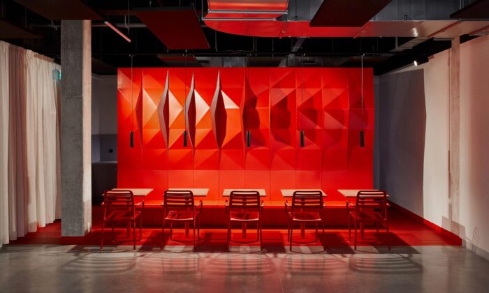 Interiér jídelny Magna Exteriors v Nymburku má výraznou červenou plastickou stěnu z plechových dílů