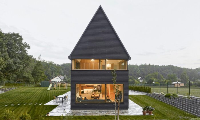 Na okraji Kolína u dubového lesa vyrostl rodinný dům s černou fasádou a moderní stodolou